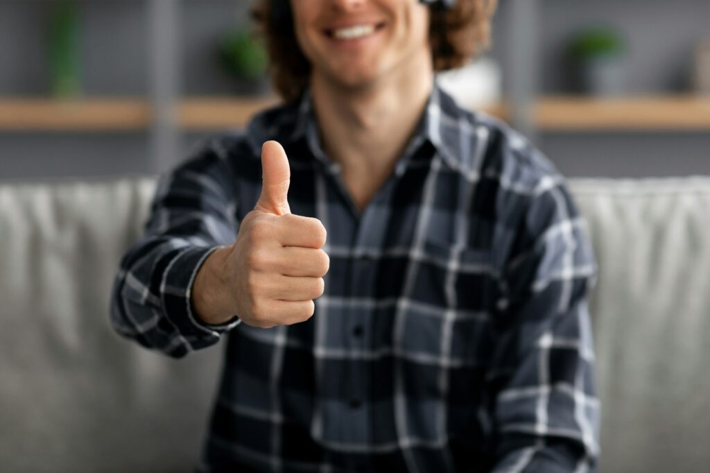 Guy Gesturing Thumbs-Up Approving Something Sitting At Home, Cropped